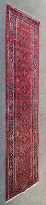 un tapis rouge accroché au mur près d'une fenêtre