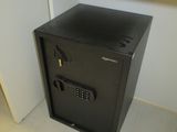 un petit coffre-fort noir posé sur un bureau dans une pièce