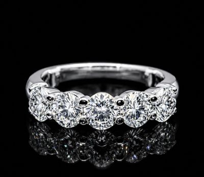 a close up of a diamond ring on a black surface