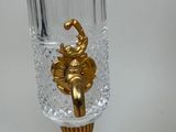 a glass vase with a gold decoration on it