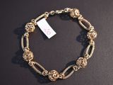a close up of a bracelet on a table with a price tag