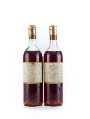 deux bouteilles de vin posées l'une à côté de l'autre sur une surface blanche