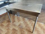 a stainless steel table in the middle of a kitchen