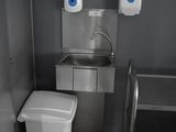 une petite salle de bains équipée d'un lavabo, de toilettes et d'une poubelle