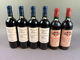 six bottles of wine are lined up in a row on a table