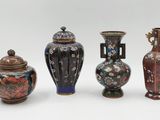 trois vases avec couvercles sont posés les uns à côté des autres sur une surface blanche