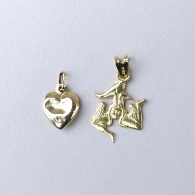 a close up of two charms on a white surface