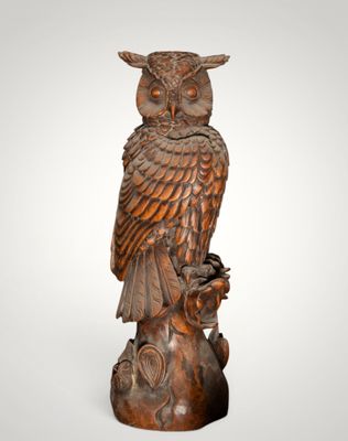 an owl statue sitting on top of a tree stump