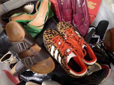 a pile of shoes and purses on the floor