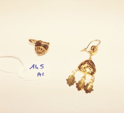 two gold earrings and a gold ring on a white surface