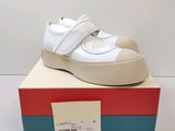 the white shoes are sitting on top of a box on a white surface