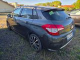 the back end of a black car parked in a field