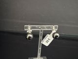 une paire de boucles d'oreilles exposées sur un présentoir