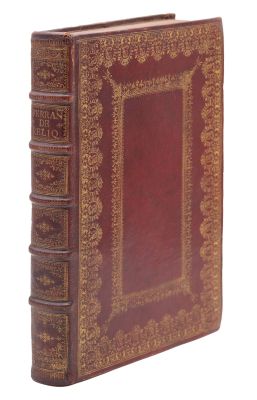 un vieux livre à la couverture rouge posé sur une surface blanche
