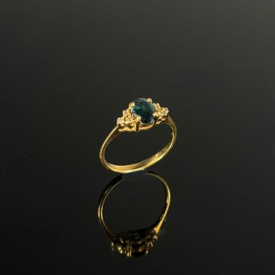 une image d'une bague en or avec une pierre en topaze bleue
