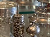 de nombreux objets en argent posés sur une table en verre dans une pièce