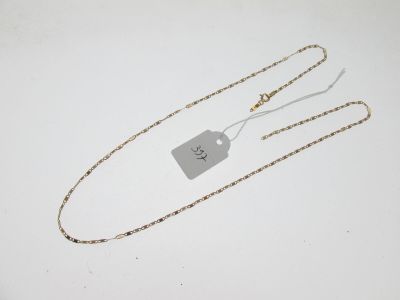 une chaîne en or à laquelle est accrochée une médaille et à laquelle est attachée une autre médaille