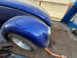 a blue car that is being worked on by a mechanic