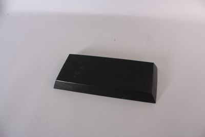 un petit objet noir sur une surface blanche