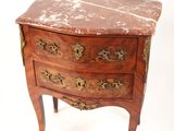 une commode au plateau en marbre posée sur une petite table