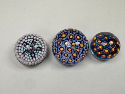 three glass magnets sitting on top of a table next to each other