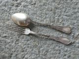 two forks and spoons on the ground next to each other