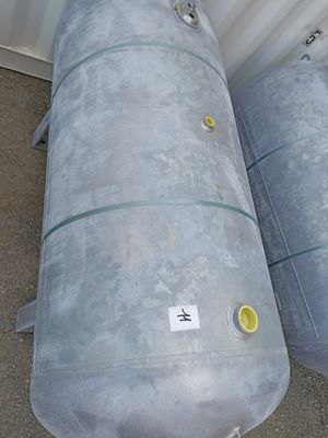 two metal tanks sitting next to each other on the ground