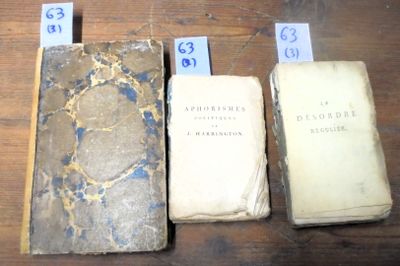 Trois vieux livres sont posés les uns à côté des autres sur une table.