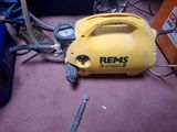a yellow air compressor sitting on the floor next to other tools