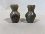 pair of green and brown vases sitting on top of a white table