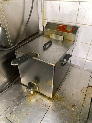 un sol sale dans une cuisine professionnelle sur lequel se trouve une friteuse