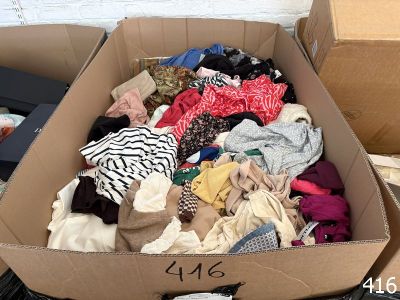 a cardboard box full of clothes on the floor