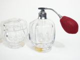 a glass bottle with a red handle and a glass cup with a red handle and a glass cup with a red handle and a glass cup with a red
