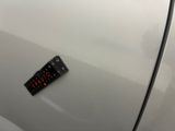 a remote control on the door handle of a white car