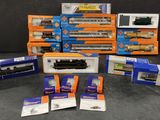 tout un tas de trains miniatures différents, rangés dans des boîtes sur la table