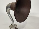 an old fashioned gramphone on a tripod stand on a white surface