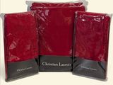 trois serviettes rouges dans des sacs en plastique, empilées les unes sur les autres