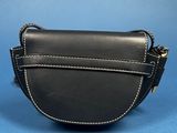 a black purse with a chain around it on a blue background