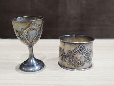 une coupe en argent et une autre coupe en argent posées sur une table