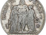 a silver coin with a picture of three people on it