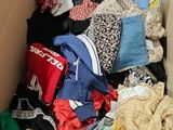 a cardboard box filled with clothes and clothing items