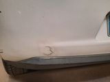 a close up of the rear bumper of a white car in a garage