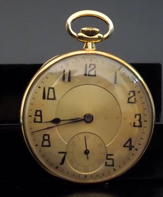 a close up of a gold pocket watch on a table