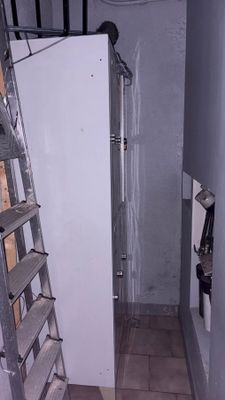 a ladder that is next to a refrigerator in a room