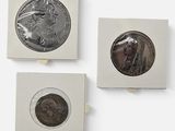 Trois types différents de pièces d'argent et de bronze sont exposés sur un fond blanc