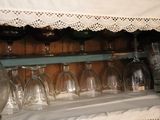 a shelf with wine glasses and a vase on it