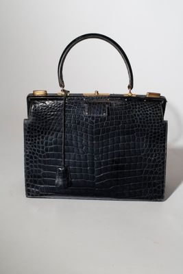 un sac à main en cuir de crocodile noir sur fond blanc