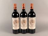 trois bouteilles de vin posées sur une table l'une à côté de l'autre