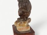 statue of a dog sitting on a rock on a marble base