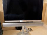 a flat screen tv sitting on a stand next to a picture frame